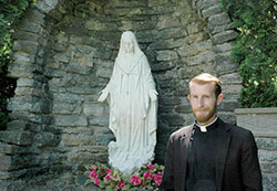 Deacon Daniel Bedel poses for a photo on May 19 at the Marian grotto behind St. John the Evangelist Church in Enochsburg—one of the two campuses of St. Catherine of Siena Parish in Decatur County. (Photo by John Shaughnessy)
