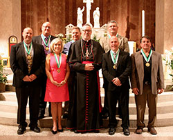 The 2014 St. John Bosco Award recipients pose for a photograph at SS. Peter and Paul Cathedral in Indianapolis with Bishop Christopher J. Coyne during the May 6 Volunteer Awards Ceremony sponsored by the archdiocese’s Catholic Youth Organization and the Office of Youth Ministry. The recipients in the front row are, from left, Dan Deak,  Kathleen Miller, Mark Liegibel and Kurt Smith. The recipients in the back row are, from left, Nick Wehlage, Patrick Soller and Ken Blackwell. (Submitted photo by Jennifer Peterson of Catholic Youth Organization)