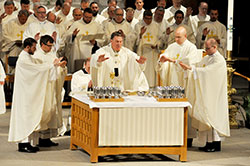 Newly ordained Fathers Daniel Bedel, left, Benjamin Syberg, Timothy Wyciskalla and David Marcotte join Archbishop Joseph W. Tobin and several priests behind them in praying part of the eucharistic prayer during a June 7 ordination Mass at SS. Peter and Paul Cathedral in Indianapolis. Earlier during the liturgy, Archbishop Tobin ordained the four men to the priesthood. (Photo by Sean Gallagher)