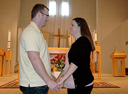 Brad Smith and Jessica Sullivan hold hands as they stand near the altar of St. Monica Church in Indianapolis, where they will be married on June 21. (Photo by John Shaughnessy)