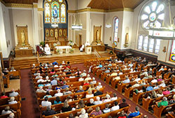 Members of St. Mary of the Immaculate Conception Parish in Rushville listen to Archbishop Joseph W. Tobin deliver a homily during a June 21 Mass in which he blessed the parish’s recently renovated church. (Photo by Sean Gallagher)