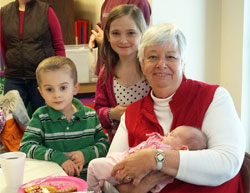 Holy Cross Sister Eileen Flavin, parish life coordinator at St. Agnes Parish in Nashville for the last nine years, holds Kailyn Wilson during a parish pancake breakfast on Feb. 9, with Alex Wilson, left, and Jamie Bube looking on. Sister Eileen is celebrating her golden jubilee as a Holy Cross sister this year. (submitted photo)