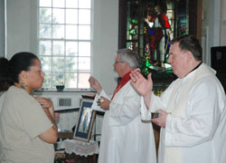 Archbishop Joseph W. Tobin blesses Erica McCaffery during a Mass that he celebrated in the chapel at the Indiana Women’s Prison in Indianapolis on June 29. To his left distributing Communion is Deacon Dan Collier. About 15 Catholic volunteers visit and teach the women in prison every week. (Photo by John Shaughnessy)