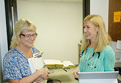 Dr. Casey Reising, right, shares a moment of joy with Kim Haley, an office assistant who works in Magnificat Family Medicine, the new Indianapolis medical practice that Reising named to honor the Blessed Mother. (Photo by John Shaughnessy)