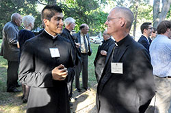 Father Martin Rodriguez, associate pastor of St. Monica Parish in Indianapolis, chats with Bishop Paul D. Etienne of Cheyenne, Wyo., on Sept. 8 on the grounds of Bishop Simon Bruté College Seminary in Indianapolis during a celebration of the 10th anniversary of the seminary’s founding. Father Rodriguez is a graduate of the seminary. Bishop Etienne served as a vice rector of the seminary while a priest of the Archdiocese of Indianapolis. (Photo by Sean Gallagher)
