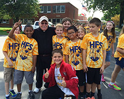 Father Daniel Atkins, pastor of Holy Family Parish in New Albany, poses on Sept. 18 with students at the parish’s school during a walkathon it sponsored. (Submitted photo)