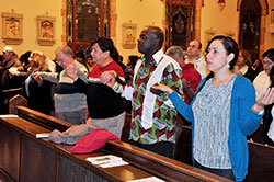 Franciscan Brother Moises Gutierrez, left, Maria Pimentel-Gannon, Paul Burns, Marlon Alfonso, Francis Blay-Mockey and Veronica Fuentes hold hands while praying the Our Father during the Nov. 3 St. Martin de Porres Mass at St. Anthony Church in Indianapolis. The annual liturgy, sponsored by the archdiocesan Office of Intercultural Ministry, celebrates how the Catholic Church brings together people of various cultures, ethnicities and races. St. Martin de Porres, who was biracial, was a Dominican brother who died in 1639 in Lima, Peru. (Photos by Sean Gallagher)