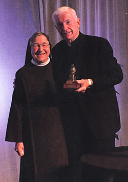 Father John Mannion receives the Blessed Maria Theresia Award from St. Francis of Perpetual Adoration Sister Jane Marie Klein, president of the Franciscan Alliance board, on Oct. 28. (Submitted photo)