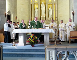 Archbishop Joseph W. Tobin celebrates Mass on Oct. 26 at St. Vincent de Paul Church in Bedford during a celebration of the 150th anniversary of the founding of the Bloomington Deanery faith community. Assisting at the Mass are Deacon David Reising, left, and Laral Tansy, master of ceremonies. Concelebrating at the Mass are Father Rick Eldred, pastor of the parish, Jesuit Father Jack Heims and Msgr. Frederick Easton. (Submitted photo)