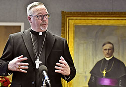Bishop Christopher J. Coyne is introduced as the 10th bishop of the Diocese of Burlington, Vt., at a news conference at diocesan headquarters in South Burlington on Dec. 22, 2014. Behind him is a portrait of the first bishop of Burlington, Bishop Louis De Goesbriand. (Photo courtesy Glenn Russell/Burlington Free Press)