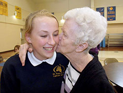 Lilly Boring of St. Rose of Lima School in Franklin gets a kiss on the cheek from Margaret Rainey. The two became friends through a pen-pal program between students at the school and residents of a nearby assisted-living community. (Submitted Photo)