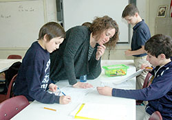 Amy Wilson’s ability to connect with students of all academic levels is one of the reasons the fifth-grade teacher at St. Roch School in Indianapolis has been chosen as this year’s recipient of the Saint Theodora Guérin Excellence in Education Award, the highest honor for a Catholic educator in the archdiocese. Here, Wilson helps Joey Luttrell, seated, with a grammar exercise while Jackson Cothron, left, works on the assignment. In the background, Anthony Stewart checks his paper. (Photo by John Shaughnessy)