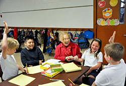 At 92, Rachel Joyce shares a laugh with four of the third-grade students that she tutors at St. Christopher School in Indianapolis. From left, Noah Ratz, Alex Rios, Shelby Rendes and Matthew Hosp join in the joy as Joyce adds fun and work in a lesson about multiplication. (Photo by John Shaughnessy)