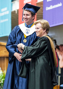 Scott Hoyland, class co-salutatorian, is pictured with school president Joan Hurley after receiving his diploma at Our Lady of Providence Jr.-Sr. High School in Clarksville on June 1, 2014. (Photo by Steve Koopman)