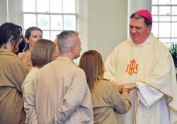 Inmates at the Indiana Women’s Prison in Indianapolis line up to meet Archbishop Joseph W. Tobin as he greets Alicia Brown after a Mother’s Day Mass he celebrated at the prison on May 10. (Photo by Natalie Hoefer)