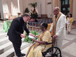 Archbishop Joseph W. Tobin presents an Intercultural Pastoral Formation Institute graduation certificate to Mynelle Gardner of Holy Angels Parish in Indianapolis on May 16 at SS. Peter and Paul Cathedral in Indianapolis. Also pictured is Hollis Thomas, a member of St. Monica Parish in Indianapolis, who also graduated from the Father Boniface Hardin Program for black Catholics. (Photo by Mike Krokos)