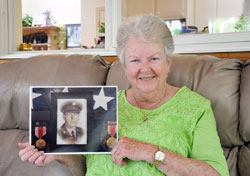 After nearly 60 years of wondering about the life of her biological father, Muriel “Mimi” Riffle finally learned about him—a journey of faith that also led her to a new family connection. Here, the member of St. Agnes Parish in Nashville poses with a photo of her father, Francis Flagg, who served in the U.S. Army during World War II. (Photo by John Shaughnessy)