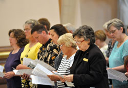 A group from Most Sacred Heart of Jesus and St. Augustine parishes, both in Jeffersonville, sing the entrance hymn at the Mass for the newly initiated celebrated at SS. Peter and Paul Cathedral in Indianapolis on June 14. They are Carol Smith of Sacred Heart Parish, left, Dorothy Kelly of Sacred Heart Parish, William and Janet Phillips of Sacred Heart Parish, Terri Lugo of St. Augustine Parish and Ann Northam, director of religious education for the two parishes. (Photo by Natalie Hoefer)