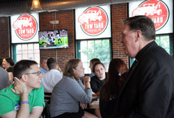Andrew Costello, a member of St. Joan of Arc Parish in Indianapolis, smiles during a conversation with Archbishop Joseph W. Tobin on June 17. They chatted shortly before the archbishop gave a talk to about 150 young adults during a Theology on Tap get-together in Indianapolis. (Photo by John Shaughnessy)
