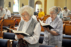 Franciscan Sisters Janice Scheidler, left, and Ruthann Boyle sing during a Mass celebrated on June 18 in the motherhouse chapel of the Congregation of the Sisters of the Third Order of St. Francis in Oldenburg. Sister Janice ministered for many years at Marian University in Indianapolis, which the Oldenburg Franciscans founded in 1937. Sister Ruthann previously served as a missionary in Papua New Guinea. (Photo by Sean Gallagher)