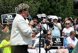 People hold signs for the #WomenBetrayed rally in Indianapolis on July 28 as Susan Swayze gives a speech. Swayze is vice president of Indiana Right to Life and national women’s pro-life caucus coordinator of Susan B. Anthony List. The rally was one of 60 held nationwide, including one in Bloomington, to call for an investigation and national defunding of the abortion provider in light of recent videos revealing the organization’s selling of body parts of aborted children. Nearly 200 people attended the Indianapolis rally. (Photo by Natalie Hoefer)