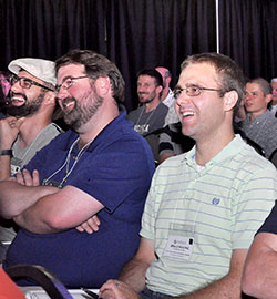 Quanah Jeffires, second from left, and Brad Macke laugh during a general session of the St. John Bosco catechetical conference at Franciscan University of Steubenville in Ohio, on July 16. Jeffries teaches religion at Cathedral High School in Indianapolis, and Macke teaches religion and serves as campus minister at Oldenburg Academy in Oldenburg. (Photo by Natalie Hoefer) 