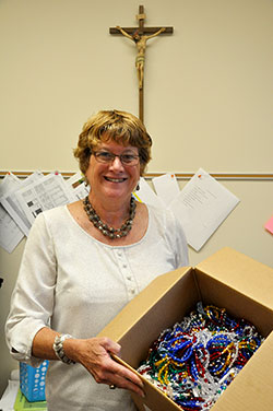 As the principal of the new St. Anthony Catholic School in Indianapolis, Cindy Greer proudly displays the gift of 300 handmade rosaries that she received from two strangers who were thrilled to learn the school was making the transition this school year from a charter school to a Catholic school. (Photo by John Shaughnessy)
