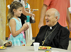 Msgr. Jeffrey Steenson smiles while speaking on Sept. 6 with Christine Janiec at Our Lady of the Most Holy Rosary Parish in Indianapolis. As the leader of the Personal Ordinariate of the Chair of St. Peter, Msgr. Steenson leads Anglicans and Episcopalians across the U.S. and Canada who have been received into the full communion of the Church, and seek to retain their spiritual and liturgical traditions. Members of the ordinariate in Indiana worship at Holy Rosary, where a Mass is celebrated weekly according to its Vatican-approved texts. (Photo by Sean Gallagher) 