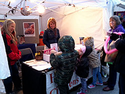 Betty McKinley, left, and Sherry White, both members of St. Michael Parish in Greenfield, talk with children about the models of babies at various stages of fetal development at the Riley Festival in Greenfield on Oct. 2. The St. Michael pro-life group has provided volunteers for the Hancock County Citizens for Life booth for the past 33 years. (Photo by Natalie Hoefer)