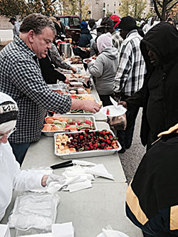 Members of the volunteer group Beggars for the Poor serve a gourmet meal to the homeless in downtown Indianapolis on Oct. 17. The ‘banquet level’ menu became available through the generosity of Bishop Chatard High School in Indianapolis. (Submitted photo)