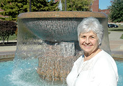 When Franciscan Sister Monica Zore was asked where she wanted to have her photo taken at Marian University in Indianapolis, the longtime math instructor chose the school’s fountain, explaining, “It’s a reminder of God’s extravagant, overflowing love. It’s constantly pouring out, and it never runs out.” (Photo by John Shaughnessy)