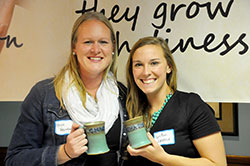 Erica Heinekamp, left, and LeeAnn Zatkulak pose with the handmade mugs they received as the first winners of the Mary and Martha Awards from the Sisters of St. Benedict at Our Lady of Grace Monastery in Beech Grove. Heienkamp, recipient of the Mary “Heart of Prayer” Award, and Zatkulak, recipient of the Martha “Heart of Service” Award, were honored at a reception at the monastery on Oct. 25. (Photo by Natalie Hoefer)