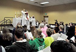 Father C. Ryan McCarthy elevates a chalice on Nov. 20 during a celebration of the extraordinary form of the Mass at the Indiana Convention Center in Indianapolis. The liturgy, attended by some 250 youths, took place during the National Catholic Youth Conference. (Photo by Sean Gallagher)