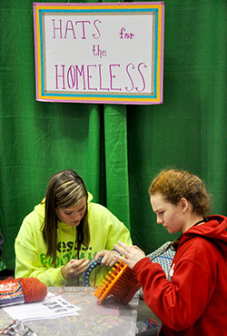 Katie Schisler, left, and Clare Kelly, both of the Diocese of Wilmington, Del., knit hats for the homeless as an act of service on Nov. 20 during the National Catholic Youth Conference in Indianapolis. (Photo by Natalie Hoefer)