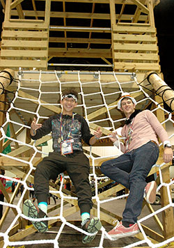 Jacob Riley, left, and Quinton Bell, both members of St. Ambrose Parish in Anderson, Ind., in the Lafayette Diocese, pose on the rope net that is part of the tree house that was at the center of Camp Tekakwitha, NCYC’s interactive theme park. (Photo by John Shaughnessy)