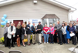 Staff, volunteers and supporters smile as the ribbon is cut during St. Elizabeth’s Catholic Charities’ dedication of its new building to house Marie’s Ministry, the agency’s resource distribution center in New Albany. (Submitted photo by Patricia Happel Cornwell)