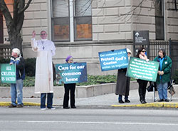 Catholic supporters of the United Nations climate change conference held in Paris on Nov. 30-Dec.11 hold signs in front of SS. Peter and Paul Cathedral in Indianapolis on Dec. 3 to raise awareness of Catholic support of the talks per Pope Francis’ call to care for creation in his encyclical, “Laudato Si’: On Care for our Common Home.” (Photo by Natalie Hoefer)