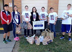 Members of the youth group at St. Anthony of Padua Parish in Clarksville pose by the cans they collected by going door to door in a neighborhood—one of many service projects during Food Fast, their annual 24-hour fasting and service event, on Feb. 20. (Submitted photo by Stacy Gillenwater)