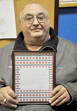 In this April 4 photo at Terre Haute Catholic Charities Foodbank, employee Dan Snider holds the letter that Anthony LePorte wrote to him at the age of 14, stating that Snider was “the father I always wanted.” (Photo by Natalie Hoefer)