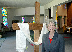 A time of great sorrow has led to the life-changing gift of reconciliation for Lynn Lineback, who is pictured here by a cross inside Holy Family Church in Richmond. (Photo by John Shaughnessy)