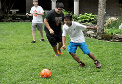 Thomas Thang, right, and Josiah Guerra-Cristobal, play with a soccer ball on June 17, 2015, at Bishop Simon Bruté College Seminary in Indianapolis during its annual Bishop Bruté Days, a vocations retreat and camping experience for teenage boys. Looking on is Nathan Herr, left. (File photo by Sean Gallagher)