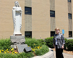 Joan Hurley, president of Our Lady of Providence Jr./Sr. High School in Clarksville, stands next to the statue of Our Lady of Providence, which has graced the school grounds since the students of the Class of 1960 and the Saint Maria Goretti Sodality raised the money to purchase the statue in 1960. (Submitted photo)