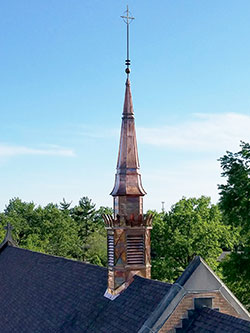 The new steeple atop St. Michael the Archangel Church in Indianapolis shines in the sun on May 13. The copper steeple is a replica of the one that was blown down by a storm nearly a year ago. (Submitted photo by Jose Martinez)
