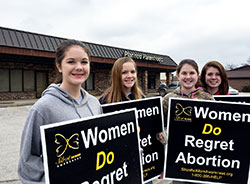Erin Pfister, Celine Mitchell, Claire Pfister and Cortney Pfister, all members of St. Patrick Parish in Terre Haute, stand in front of the Planned Parenthood referral center in Terre Haute on Jan. 22, 2015, for the solemn observance of the Roe v. Wade decision. Planned Parenthood of Indiana and Kentucky, Inc., announced on June 30 that the referral facility will close on July 20. (Submitted photo by Tom McBroom)