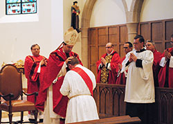 Bishop Steven J. Lopes, shepherd of the Personal Ordinariate of the Chair of St. Peter, ritually lays hands on transitional Deacon Luke Reese during a June 29 priesthood ordination Mass at the Cathedral of Our Lady of Walsingham in Houston. Father Reese, a priest of the ordinariate, will minister to members of the ordinariate at Our Lady of the Most Holy Rosary Parish in Indianapolis, to other members of the parish and at other archdiocesan parishes. A husband and father of seven and former Anglican priest, he will be the first married priest to minister in the archdiocese. (Submitted photo)