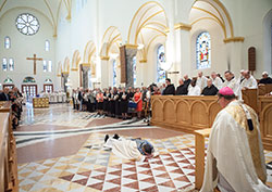 Benedictine Archabbot Kurt Stasiak lays prostrate on July 26 on the floor of the Archabbey Church of Our Lady of Einsiedeln in St. Meinrad during a praying of a litany of the saints that was part of the Mass in which the newly elected leader of Saint Meinrad Archabbey was solemnly blessed by Archbishop Joseph W. Tobin, kneeling at right. (Photo courtesy of Saint Meinrad Archabbey)