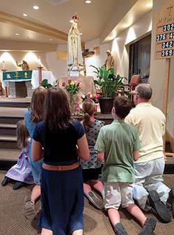 The Reynolds family, who are members of St. John Paul II Parish in Clark County, pray the rosary before the traveling pilgrimage statue of Our Lady of Fatima in the parish’s St. Paul Church in Sellersburg on Aug. 21. They are Elizabeth, left, Barbara, Rebecca, Anna Kate, William and Joseph. (Photo by Natalie Hoefer)