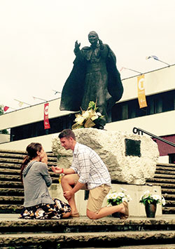Stephen Janssen offers an engagement ring to Kara Gregg on July 28 in Krakow, Poland, beneath a statue of St. John Paul II. Stephen and Kara were among the 64 young adults from the Archdiocese of Indianapolis who traveled to Krakow for 2016 World Youth Day in late July. (Submitted photo)