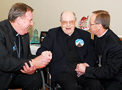 Cardinal-designate Joseph W. Tobin, left, archbishop of Indianapolis, shares a joyous moment on Jan. 18, 2015, with retired Father Hilary Meny and Bishop Charles C. Thompson of Evansville during the 100th birthday celebration for Father Meny, which was held at SS. Peter and Paul Parish in Haubstadt, Ind., in the Diocese of Evansville, where Father Meny grew up and lived in retirement. Father Meny died on Oct. 7. (The Message photo by Tim Lilley)