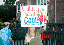 St. Thomas Aquinas School teacher Kate Krieger welcomes students with a high-five as they come to school on Oct. 5, “National Walk to School Day.”  The Indianapolis North Deanery school is one of only four Catholic schools across the country to earn the 2016 Let’s Move! Active Schools National Award. (Photo by John Shaughnessy)